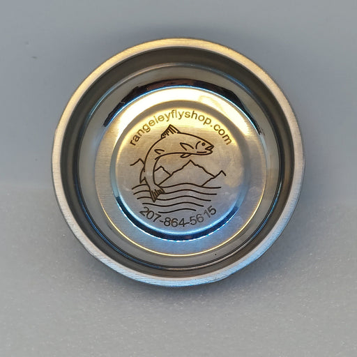 A magnetic nickel colored dish for holding beads, hooks, and flies while fly tying.  Engraved with Rangeley fly shop logo .  Shown empty