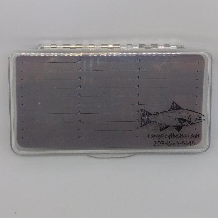 clear lidded fly box with slit gray foam - large enough for streamers or dries - decorated with a trout design and shop contact info