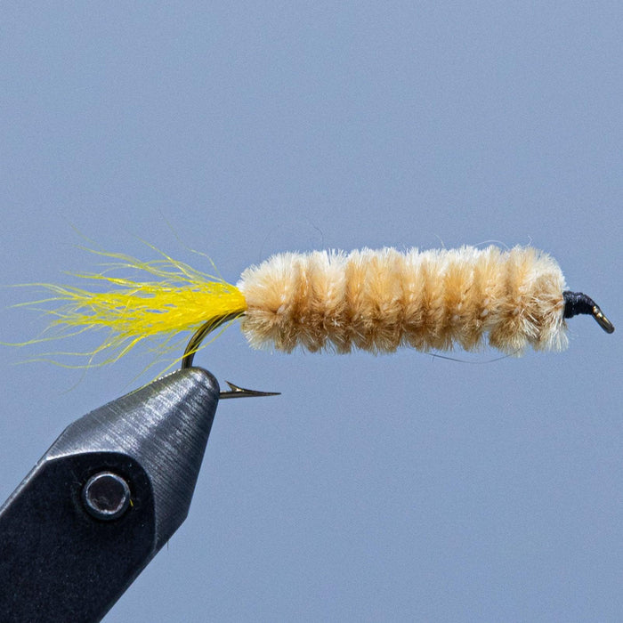 the maple syrup fishing fly has a tan chenille body with small yellow tail tied at the Rangeley Region Sport Shop