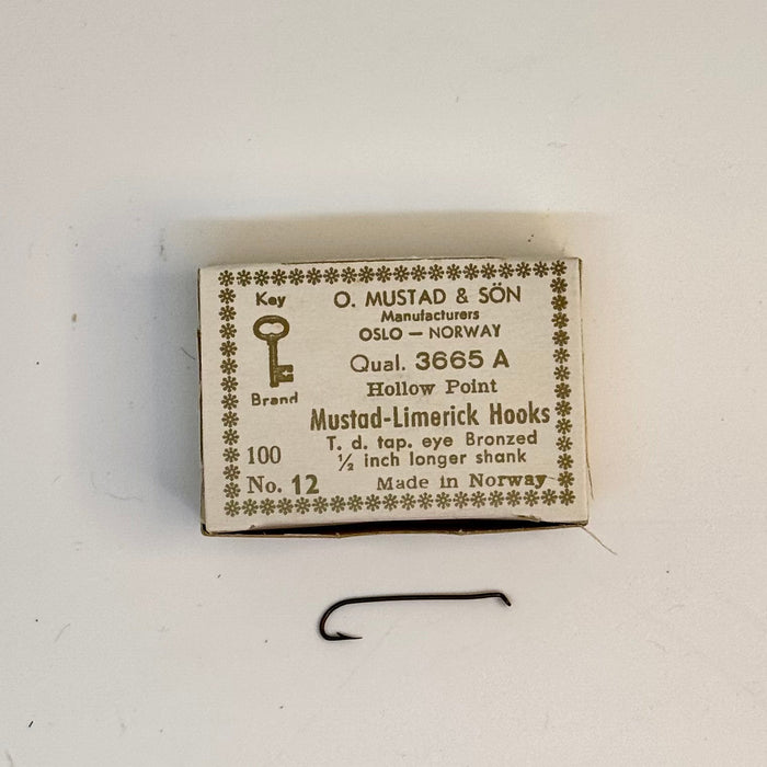 Size 12 box of Mustad hook with one hook below the box