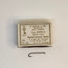 Size 12 box of Mustad hook with one hook below the box