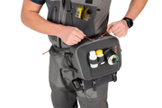 Simms hip pack worn by man, front flap open with bottles and small organizer