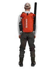 Orange rolltop backpack worn on back with shoulder straps and front storage pouch
