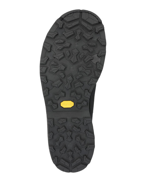 Boot sole with rugged dark tread pattern and small yellow grip label