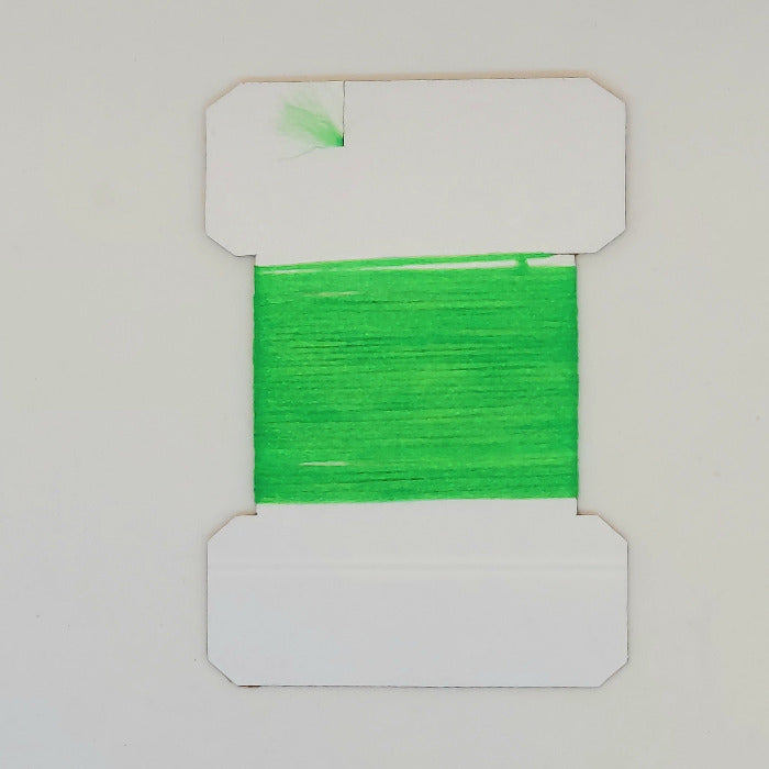 Green yarn on cards, bright green fibers wound on a white card