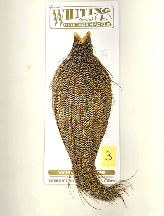 Gold and dark speckled hackle cape on backing card with flowing feather fibers.