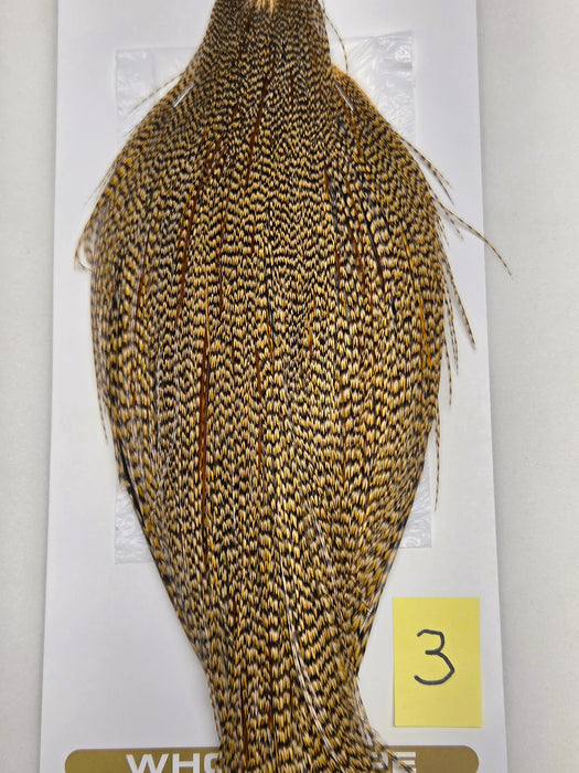 Mustard-gold and dark speckled hackle cape with fine feather fibers, side view.