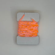 Chenille yarn bundle in bright orange, tightly looped with yarn tail visible