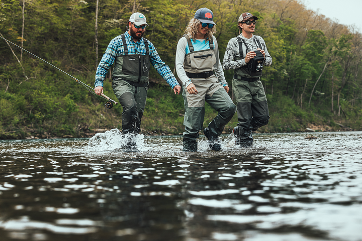 Stockingfoot waders on anglers, olive bib with chest straps and black boot uppers