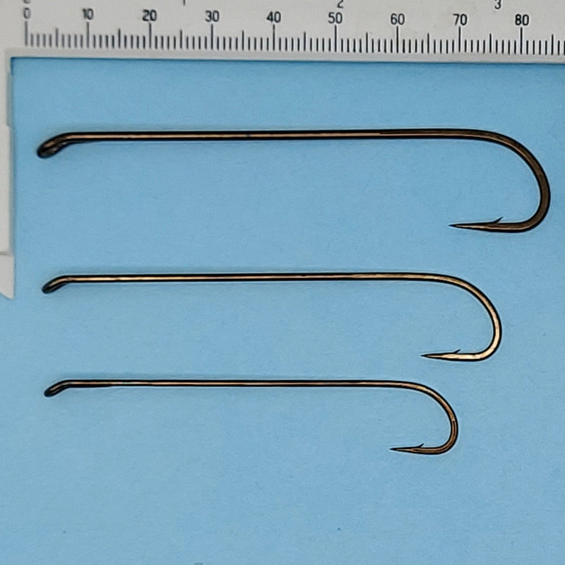 Set of three streamer fishing hooks with dark wire, sized against a ruler