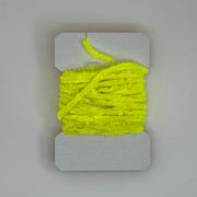 Chenille yarn bundle in neon yellow, tightly looped with yarn tail visible