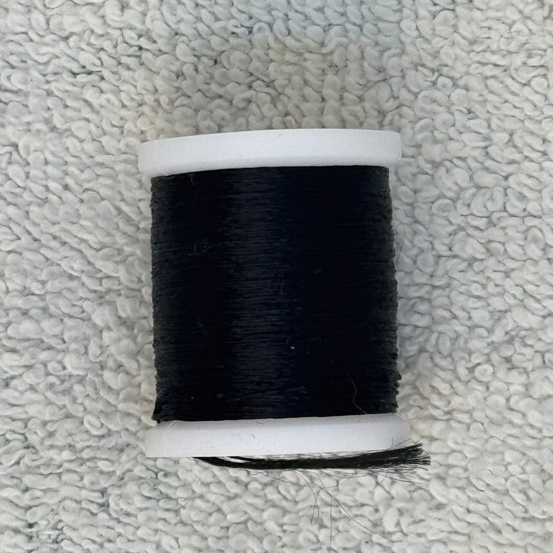 Four-strand floss spool in black with loose thread
