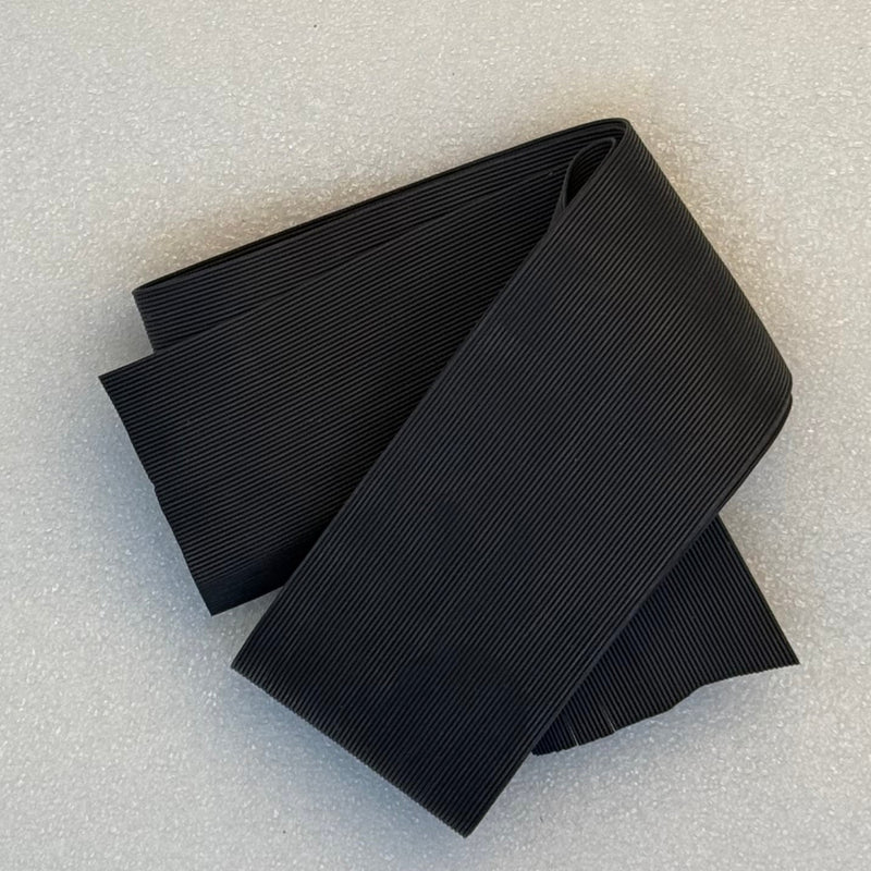Round rubber sheet, black ribbed texture, folded stack