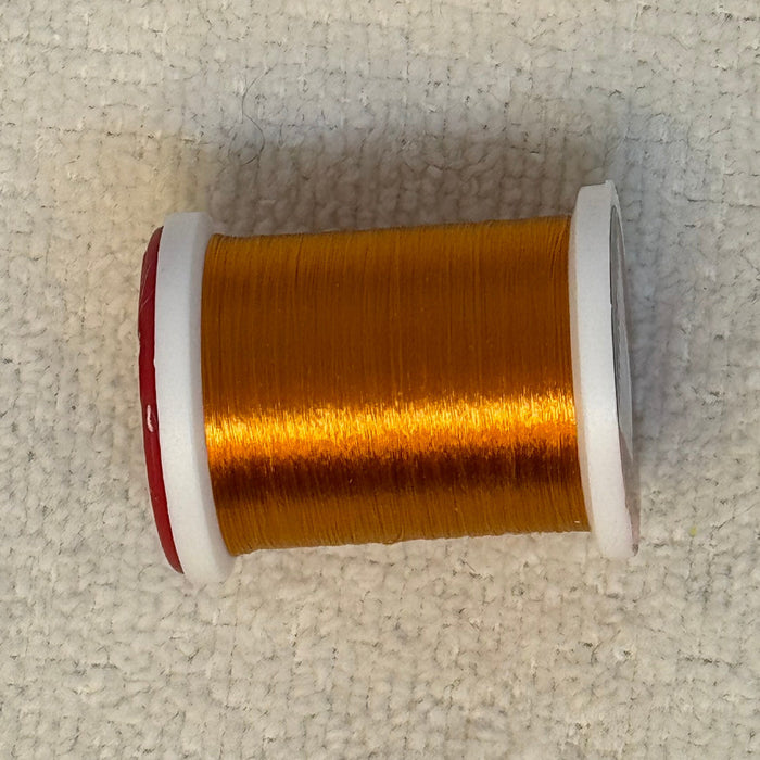 Close up spool of burnt orange ultra thread