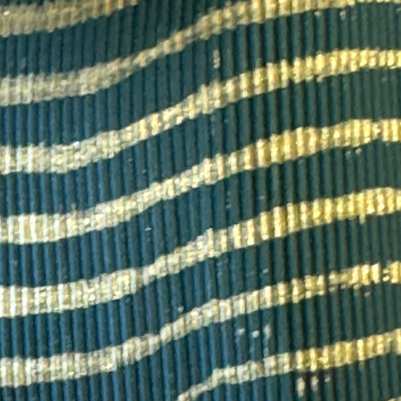 Striped round rubber sheet, teal with gold lines, close-up
