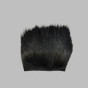 Black deer hair patch with dense dark fibers and trimmed base edge
