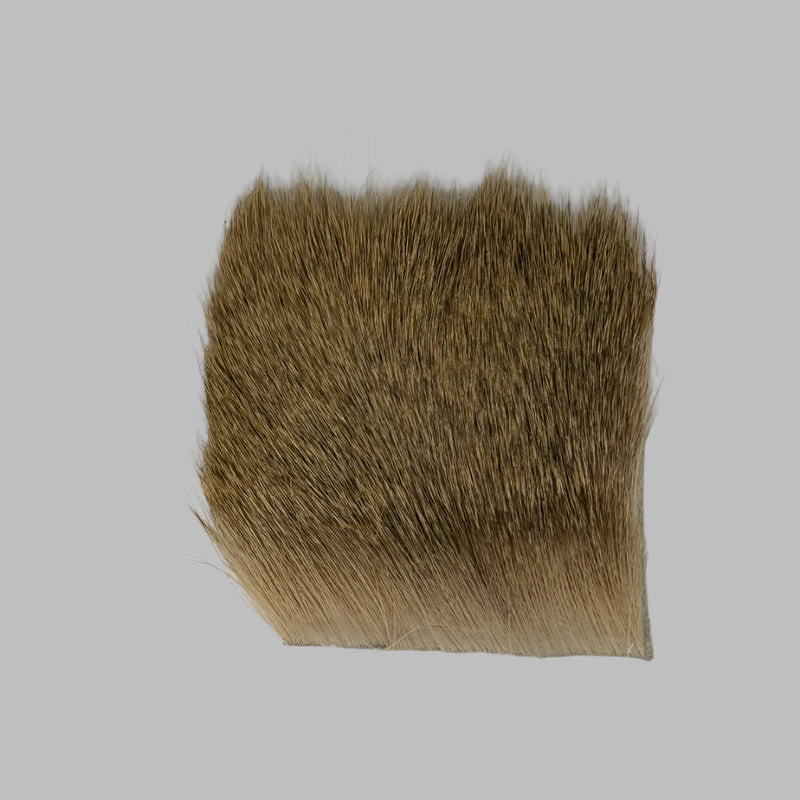 Tan and brown deer hair patch with dense short fibers and cut bottom