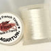 Spool of brilliant white colored thread from two angles side by side