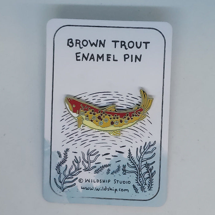 Brown trout enamel pin with speckled fish design on a backing card.