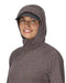 Woman wearing a brownish hooded jacket on a white background