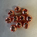 Pile of ten copper colored slotted beads