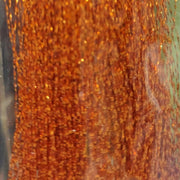 Orange sparkly tinsel fibers with warm gold glitter