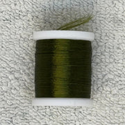 Four-strand floss spool with dark olive green thread on a cream core