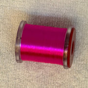 70 denier thread spool in magenta with a shiny finish