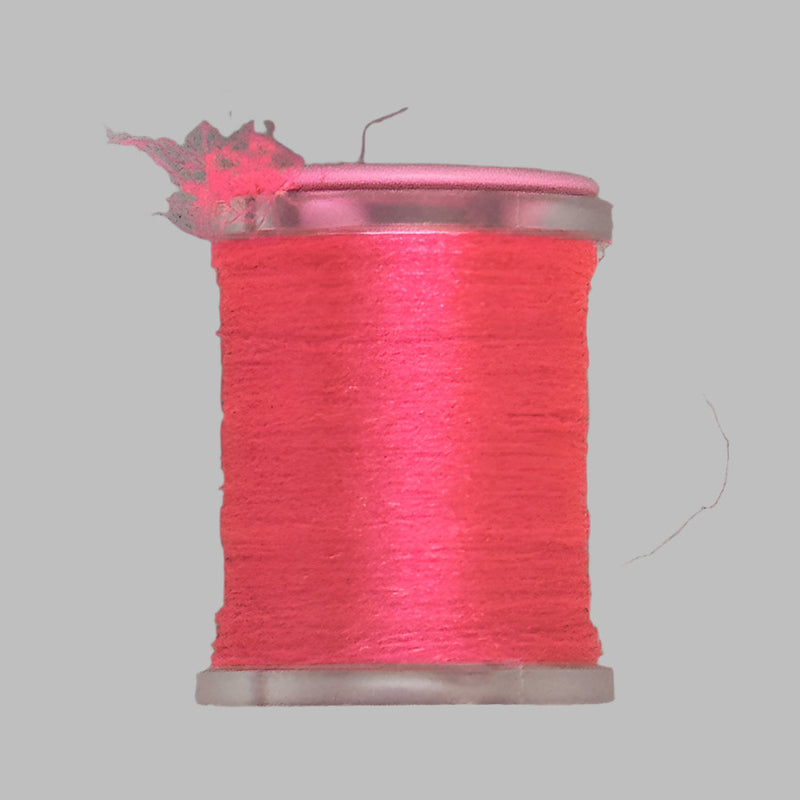 UTC Antron yarn spool in bright pinkish-red with loose thread at top