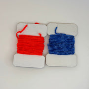 Chenille yarn spools, red and blue, on white display cards with hanging loops