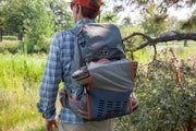 Fishpond Firehole backpack on a person, dark gray with orange side panels