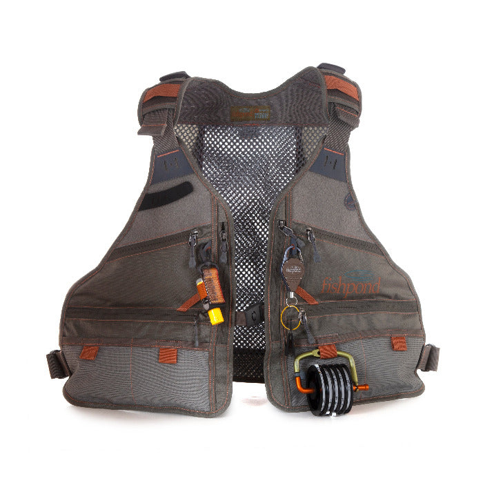 A fishpond flint hill fly fishing vest with some accesories hanging on it