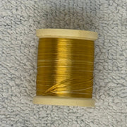 Four-strand floss spool in golden yellow with loose thread