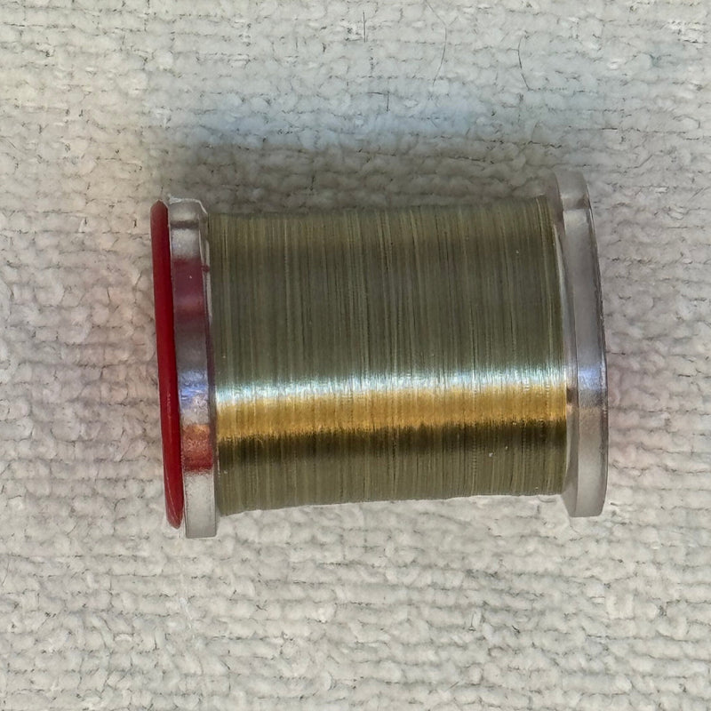 Spool of 70 denier thread in olive with gold sheen and red flanges