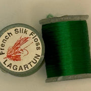 French silk floss spool with tightly wound dark green thread