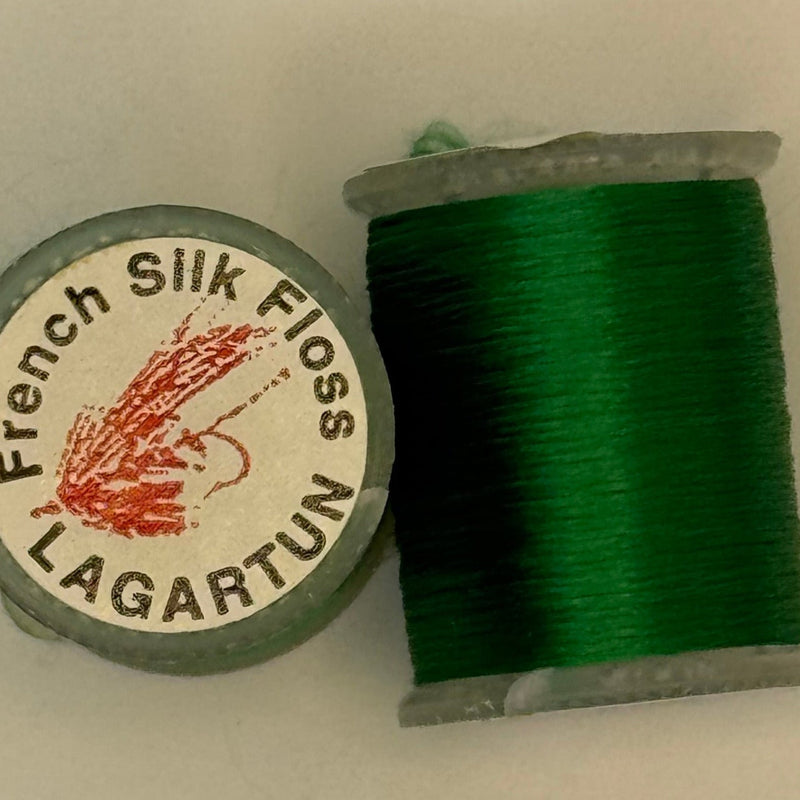 French silk floss spool with tightly wound dark green thread