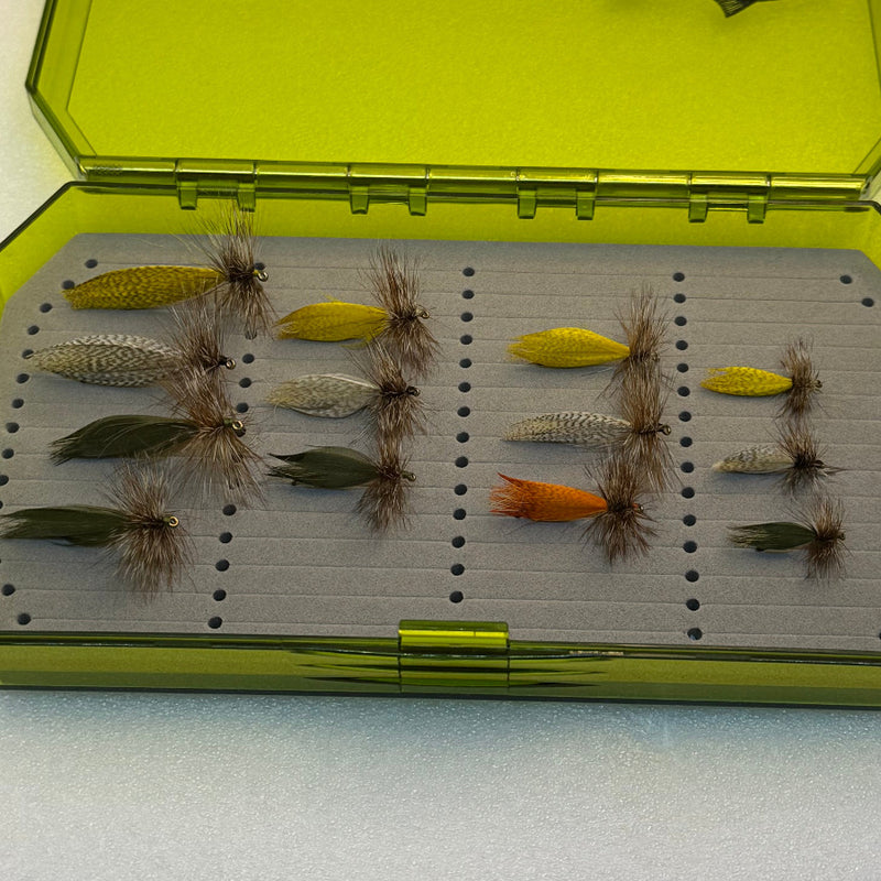 Foam tray with multiple feathered fishing flies and peg holes inside green box