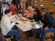 Tying lessons workshop participants seated around a central work table