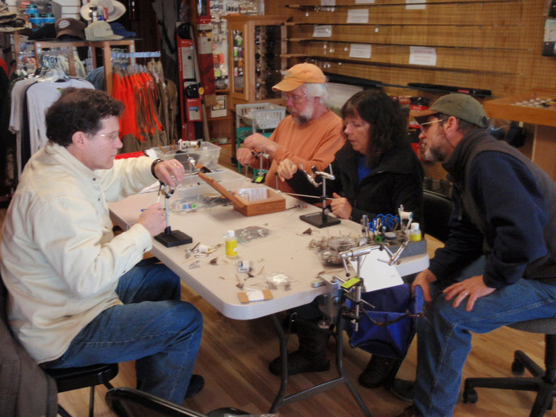 Tying lessons workshop participants seated around a central work table