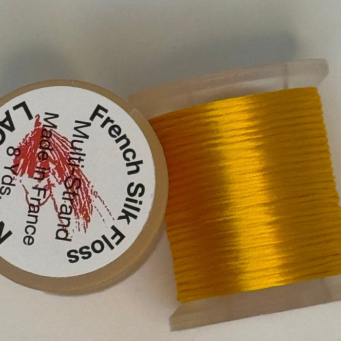 Spool of marigold colored thread from two angles side by side