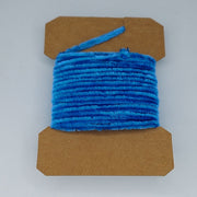 Medium rayon chenille yarn spool in medium blue with ribbed fuzzy texture