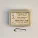 Size 10 box of Mustad hook with one hook below the box