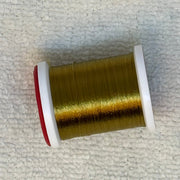 Spool of 70 denier thread in olive-gold with red side flanges