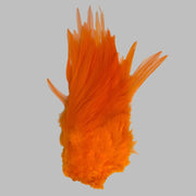 Strung rooster saddle feathers, bright orange with wispy barbs and quills.