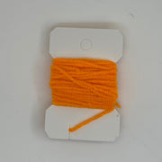 Chenille thread spool on card in bright orange with short yarn tail