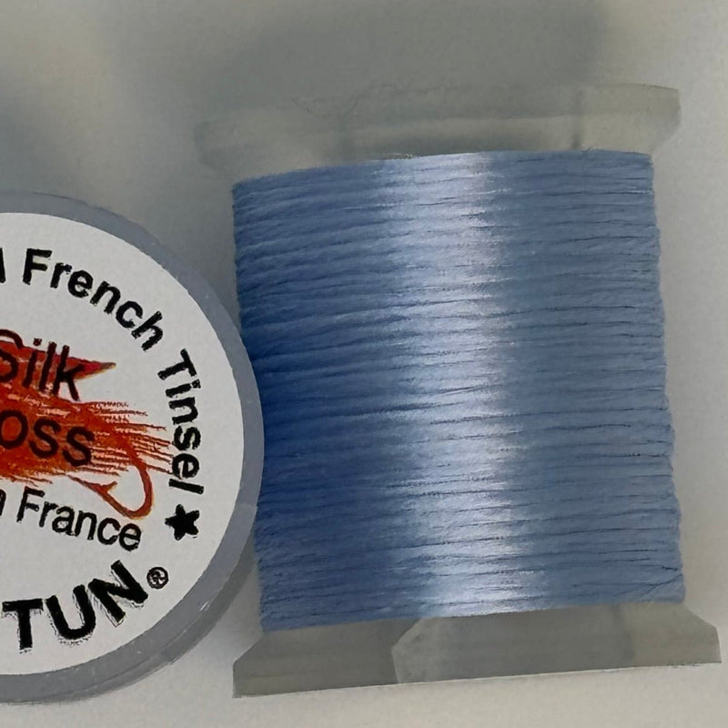 French silk floss spool with tightly wound pale blue thread
