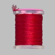 UTC Antron yarn spool in red with loose thread end above the bobbin
