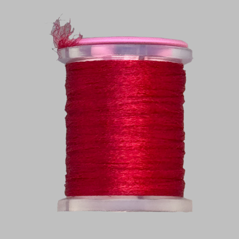 UTC Antron yarn spool in red with loose thread end above the bobbin