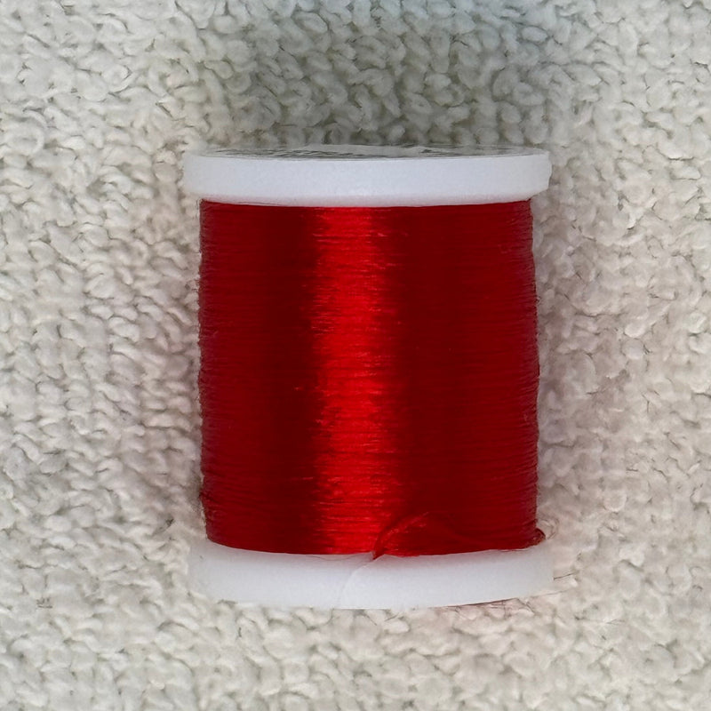 Four-strand floss spool with bright red thread on a white core