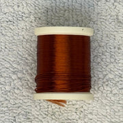Four-strand floss spool with reddish brown thread on a cream core